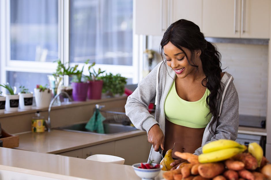 Smiling woman preparing fresh fruit in a sunlit kitchen, embodying a healthy lifestyle